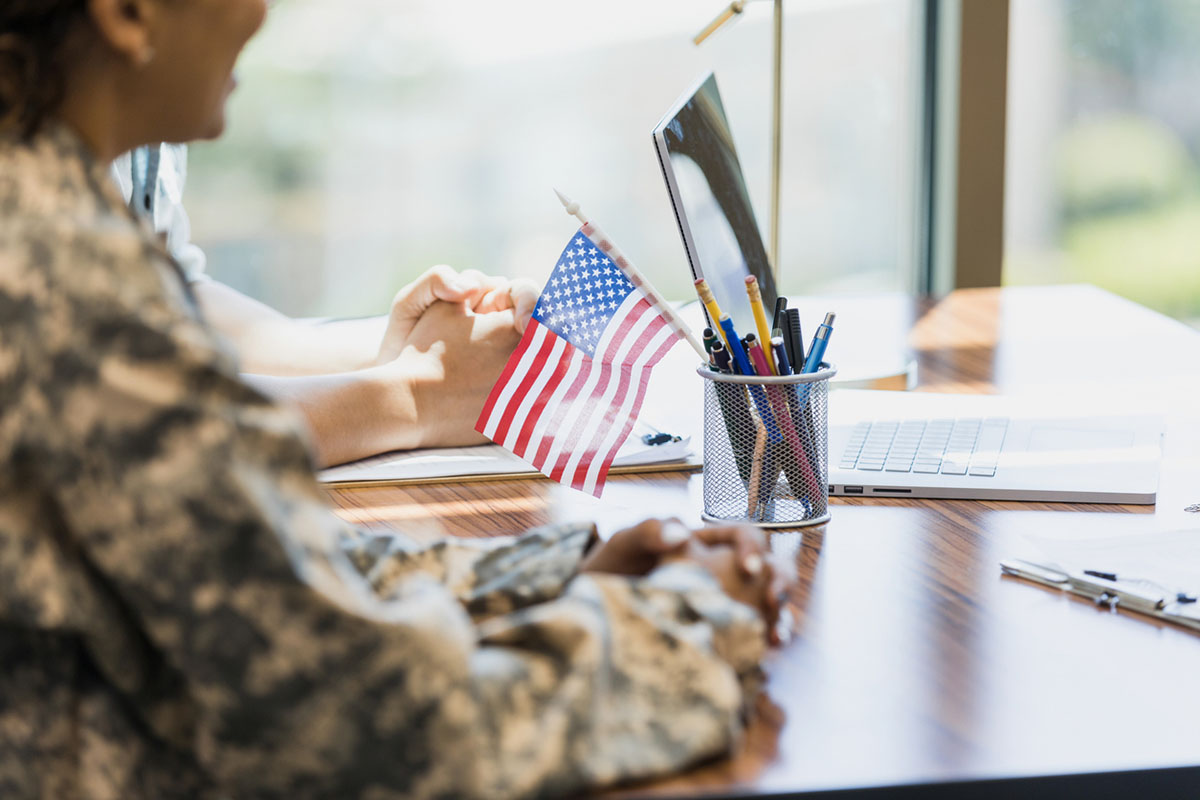 An unrecognizable female soldier and her husband wait to meet with loan officer at a military credit union.