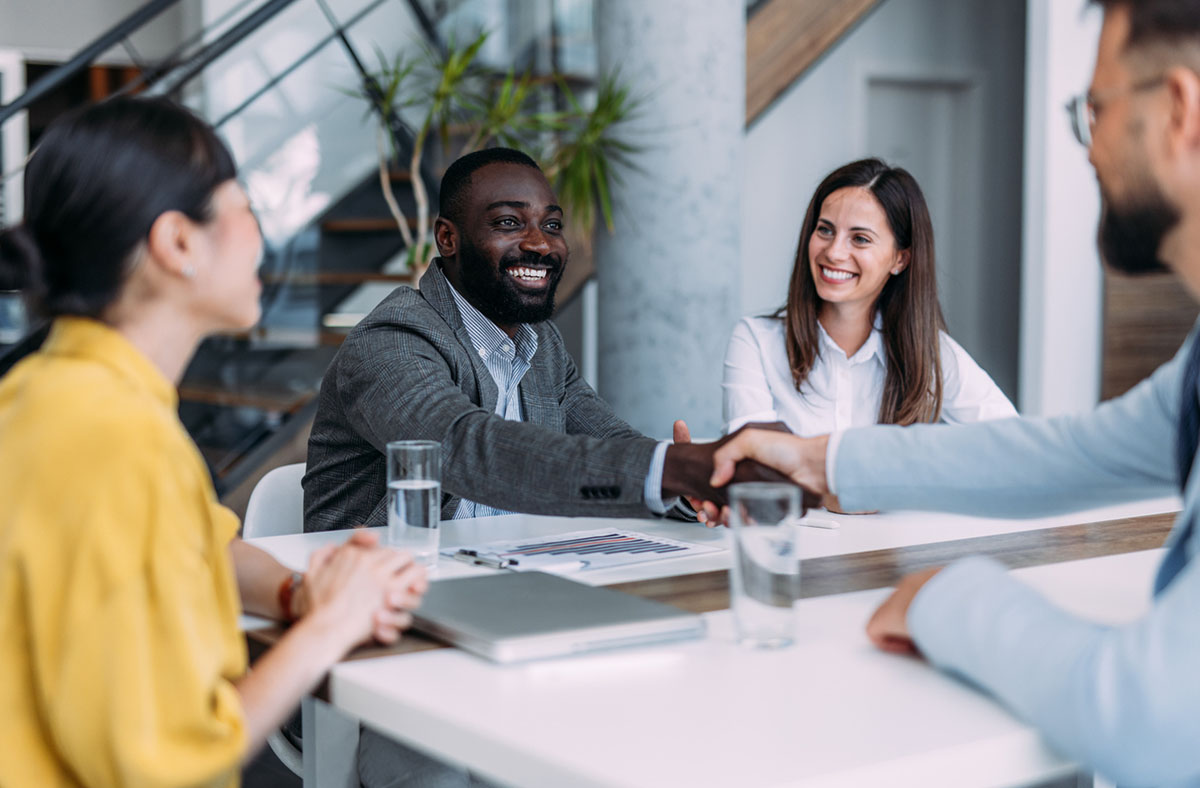 Businesspeople shaking hands across the table.