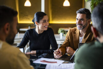 Group of co-workers sitting at table discussing project, success, achievement, teamwork