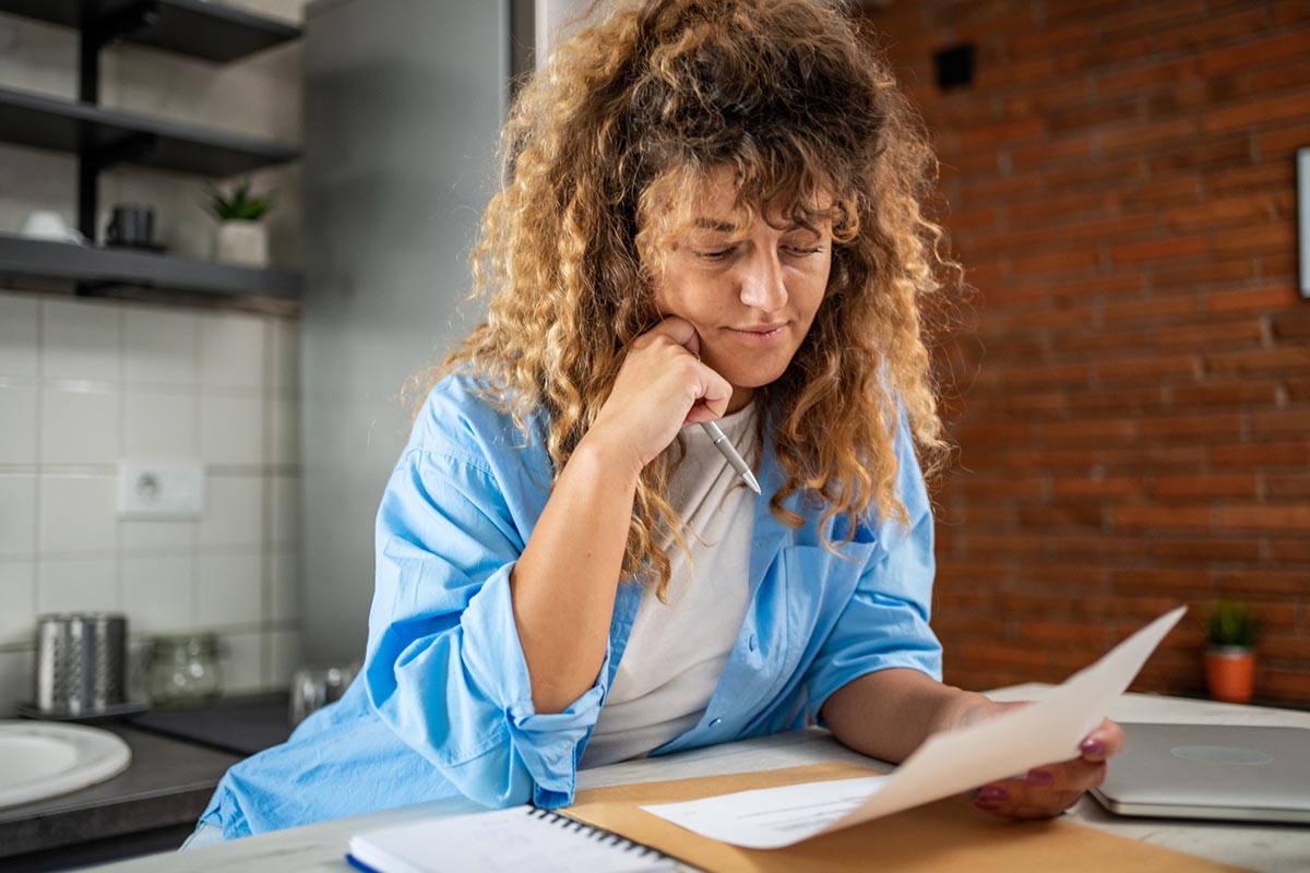 A young woman at home calculates the balance of her financial plans