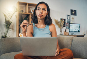 Woman thinking while on her laptop